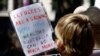 FILE - Protesters hold placards at a "Stand up for Refugees" rally held in central Sydney, Oct. 11, 2014.