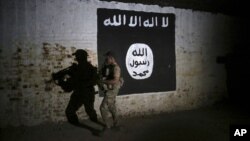 Un soldat irakien inspecte un tunnel orné d'un drapeau du groupe État islamique le 1er mars 2017.