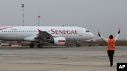 Un aiguilleur de l’air dirige un avion de Senegal Airlines à l’aéroport international de Dakar, Sénégal (archives)