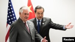 美國國務卿蒂勒森和中國外長王毅在德國波恩舉行的20國集團外長會議期間進行會晤，走向各自的座位。