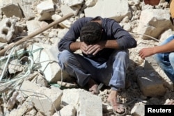 FILE - A man reacts on the rubble of damaged buildings after losing relatives to an airstrike in the besieged rebel-held al-Qaterji neighborhood of Aleppo, Syria, Oct. 11, 2016.