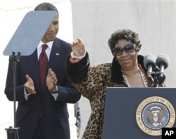 Aretha Franklin acena à multidão sob os aplausos de Obama.