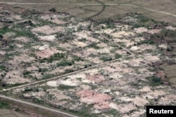 FILE - An aerial view shows burned down villages once inhabited by the Rohingya seen from the Myanmar military helicopters that carried the U.N. envoys to northern Rakhine state, Myanmar, May 1, 2018.