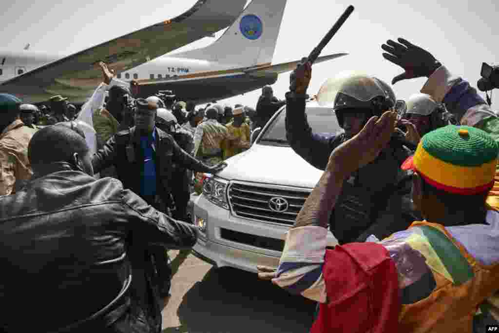 La police repoussant la foule lors du retour au Mali de l'ancien président Amadou Toumani Touré à l'aéroport de Bamako, le 24 décembre 2017.