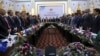 FILE - Afghan President Ashraf Ghani, center, and delegates stand for the national anthem during the Kabul Process conference, at the Presidential Palace in Kabul, Afghanistan, June 6, 2017.