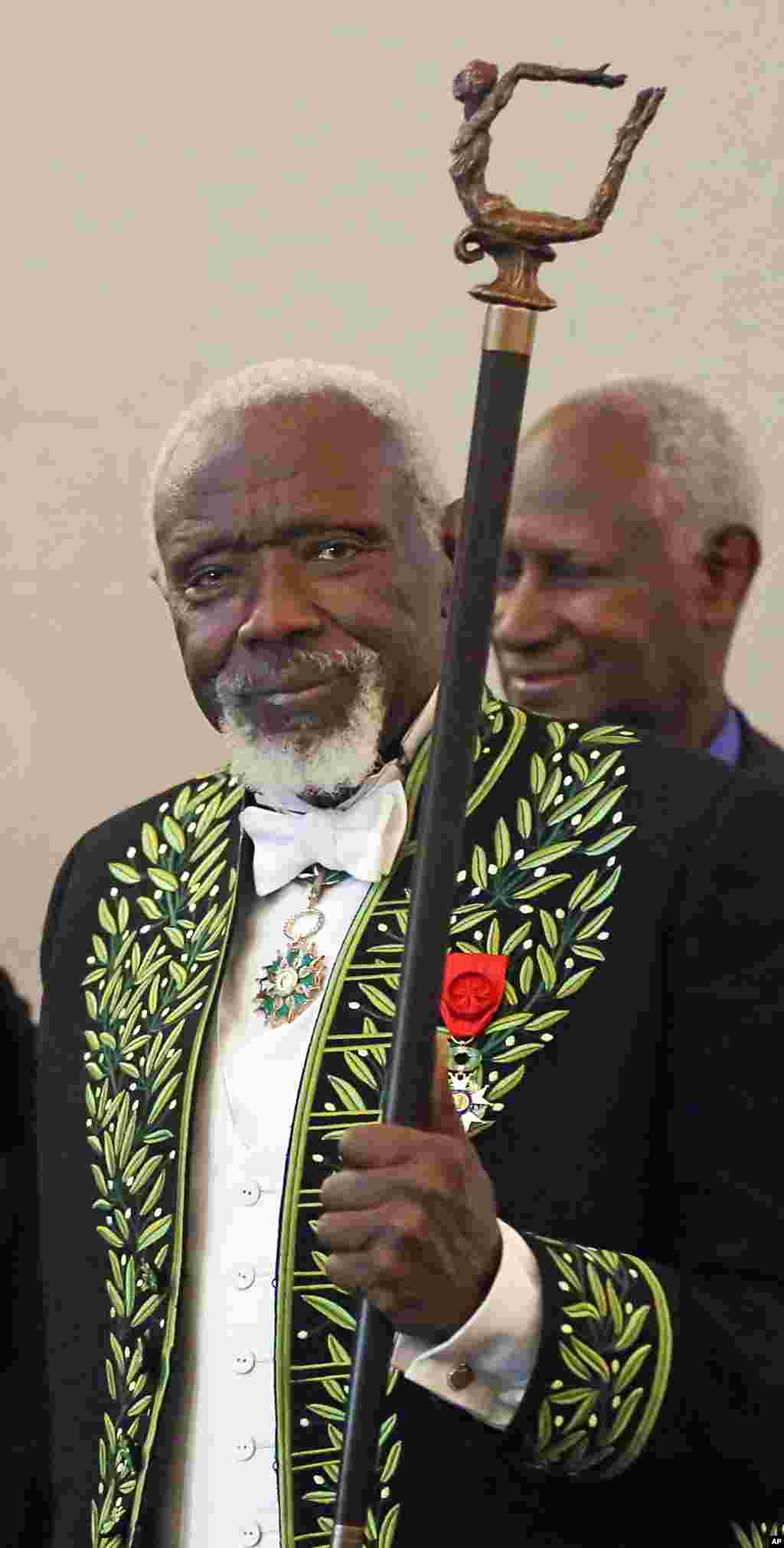 Le sculpteur sénégalais Ousmane Sow présente l'épée qu'il vient de recevoir de l'Académie française lors d'une cérémonie en France, le 11 décembre 2013.