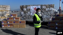 希臘雅典國際機場的一名工人站在從中國運抵的口罩等抗疫防護用品。（2020年3月21日）