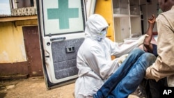 Le personnel de santé place un patient suspecté d'ètre infecté d'Ebola dans une ambulance à Freetown, Sierra Leone, le 24 septembre 2014. 