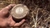 FILE - In this still image made from video taken Sept. 7, 2015, provided by the Syrian Center for Demining and Rehabilitation, a volunteer deminer takes a landmine from the ground in Daraa, Syria.