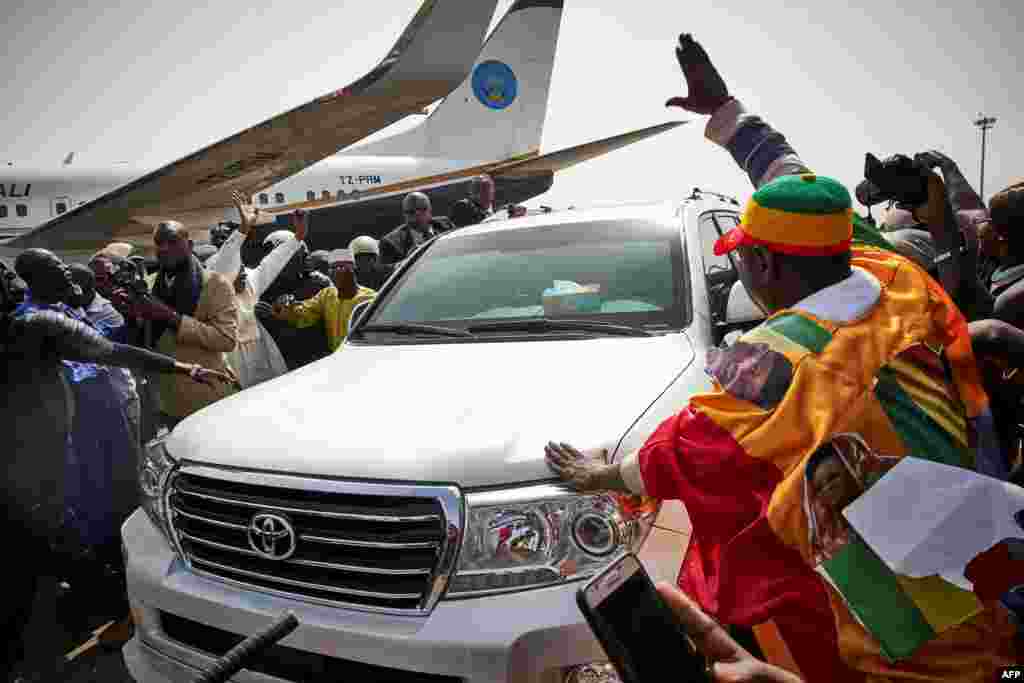 La foule salue l'ancien président Amadou Toumani Touré venant de débarquer d'un avion à Bamako, le 24 décembre 2017.