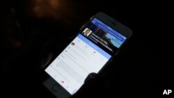 FILE PHOTO - A man views Cambodian Prime Minister Hun Sen's Facebook page on his mobile phone at a sidewalk in downtown Phnom Penh, Cambodia. 