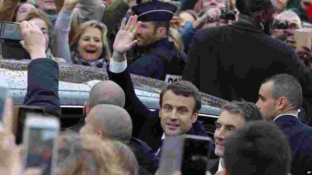 Le candidat de "En marche!" au second tour de l'élection présidentielle, Emmanuel Macron, salue avant qu'il quitte le bureau de vote.