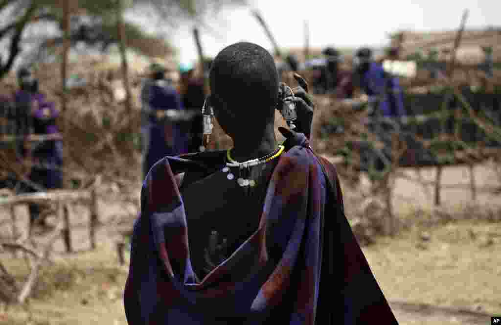 Une Maasai porte son bébé sur son dos dans un village à la périphérie de Serengeti, dans le nord de la Tanzanie, le 12 août 2013.