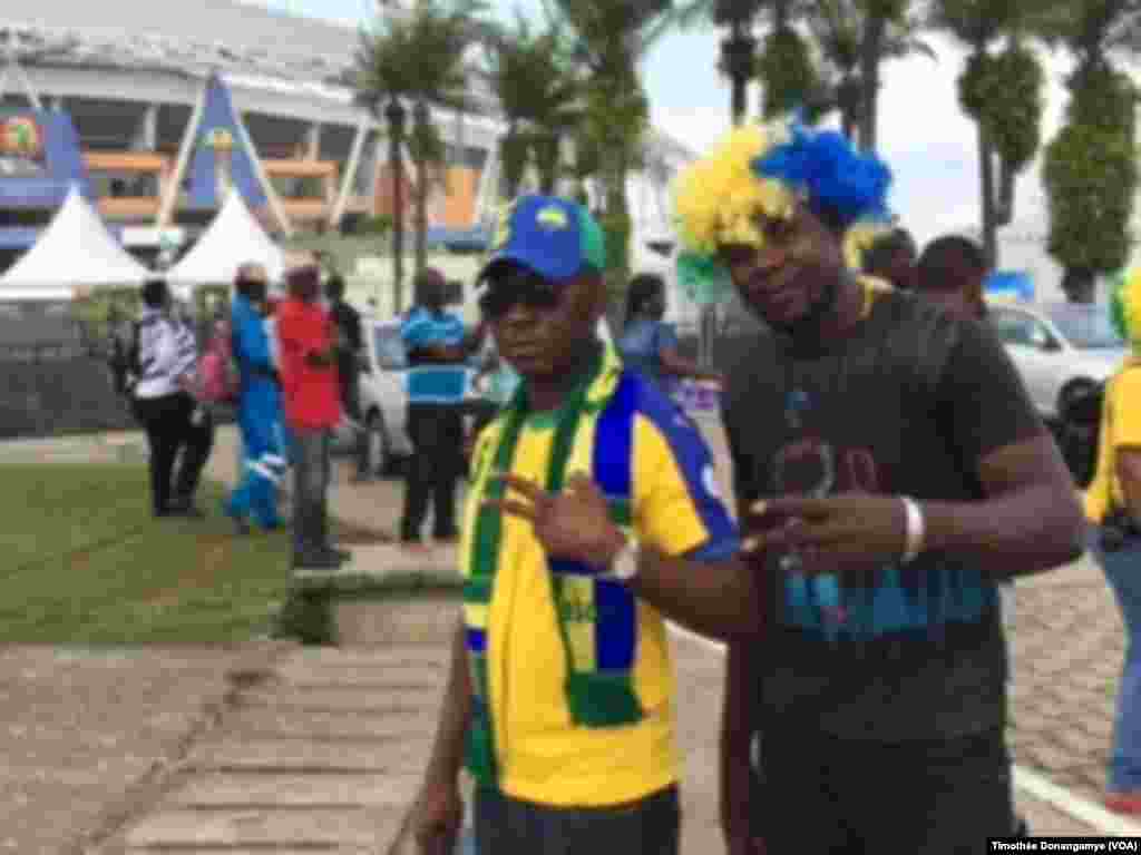 Deux fans gabonais devant le stade de Libreville sûrs d'une victoire gabonaise contre la Guinée Bissau près du stade de l’Amitié à Libreville, Gabon, 14 janvier 2017. (VOA/Timothée Donangmaye)