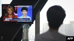 中國環球電視網主播劉欣在北京的央視總部觀看她自己與時為美國福克斯商業頻道主播的翠西·裡根所進行電視辯論的錄像。（2019年5月30日）
