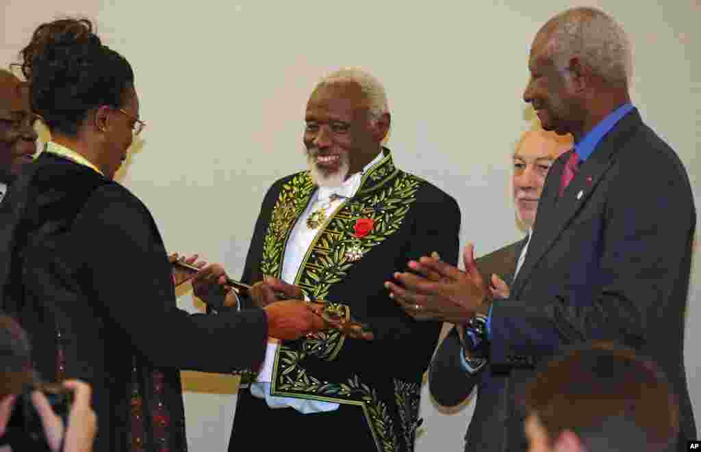 Le sculpteur sénégalais Ousmane Sow, reçoit l'épée de l'Académie française à Paris, le 11 décembre 2013.