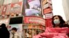 Residents wearing masks past by a screen showing a trailer for the film "Days and Nights in Wuhan" outside a mall in Wuhan in central China's Hubei province on Friday, Jan. 22, 2021. China is rolling out the state-backed film praising Wuhan ahead of…