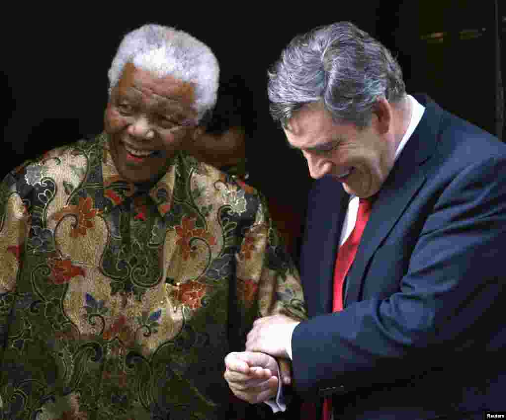 Nelson Mandela, à gauche et le Premier ministre britannique Gordon Brown, à gauche, se tiennent le bras au sortir d'une audience à Downing Street à Londres, le 28 Août 2007. 