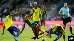 Le Gabonais Serge Ngouali, à gauche, et André Biyogo Poko, à droite, bataillent autour du ballon avec le Camerounais Edgar Salli lors du match du groupe A de la Coupe d’Afrique des nations entre le Gabon et le Cameroun au stade de l’Amitié, à Libreville, Gabon, le 22 janvier 2017.
