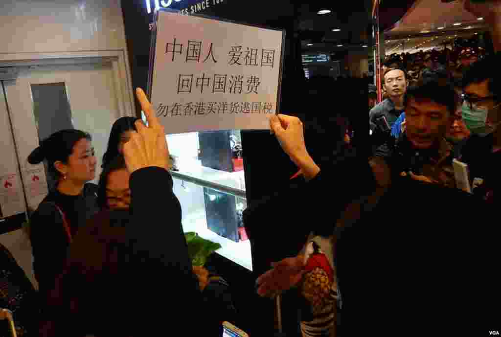 有示威者高舉標語包圍中國遊客,呼籲他們回中國消費。(美國之音湯惠芸攝)