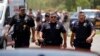 FILE - Police walk near Robb Elementary School following shootings on May 24, 2022, in Uvalde, Texas. A federal report released on Jan. 18, 2024, into the halting law enforcement response to the shootings revived scrutiny of the hundreds of officers who responded to the massacre.