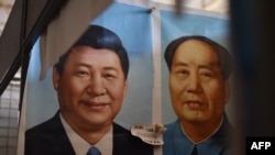 中國主席習近平與毛澤東畫像並排掛在北京的一家市場上，2017年9月19日。