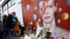Une femme maquillee au style Ziggy Stardust pleure devant une peinture murale de David Bowie à Brixton, au sud de Londres, 11 janvier 2016.