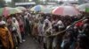 FILE - Internally displaced Congolese men and women wait for World Food Program energy biscuits to be distributed in Kibati, north of Goma, eastern DRC, Aug. 8, 2012.