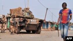Des militaires français de l’opération Sangaris observent un jeune milicien anti-Balaka circulant avec une machette à Bangui, près du quartier PK 12, Centrafrique, 23 janvier 2014.
