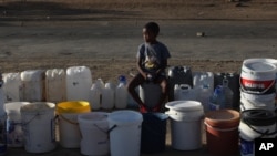 Un petit garçon fait la queue pour obtenir de l'eau gratuite de la municipalité, à Senekal, Afrique du Sud, le 7 janvier 2016. (AP Photo/Denis Farrell)