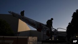 Пожарный спускается по лестнице возле здания, где января 2025 года произошла авиакатастрофа, в Фуллертоне, штат Калифорния.