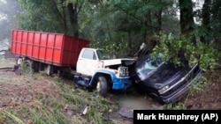 Un camion et une voiture dans un ruisseau le dimanche 22 août 2021, après avoir été emportés par les eaux la veille à McEwen, dans le centre du Tennessee