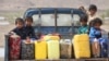 Children ride on the back of a truck loaded with water jerrycans at a camp for internally displaced people in the Dhanah area of the central province of Marib, Yemen, April 30, 2016.