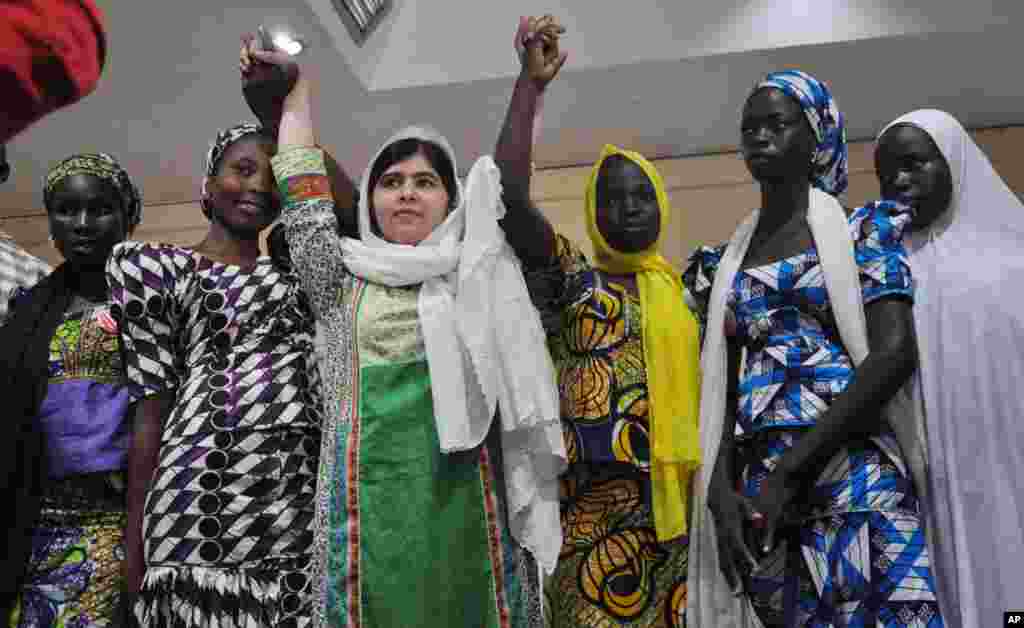 La défenseuse pakistanaise de l’éducation pour jeunes filles, Malala Yousafzai, a recu le Prix Noble de paix. Elle s’affiche, au cours d’une conférence de presse, avec des filles d’école secondaire qui ont échappé à un enlèvement, à Abudja, Nigeria, le 14 juillet 2014.(AP Photo/Olamikan Gbemiga)