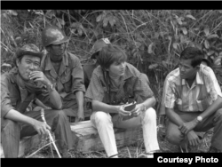 លោកស្រី Kate Webb ជាមួយ​នឹង​ទាហាន និង​អ្នក​បើក​រថយន្ត​នៅ​ពេល​លោកស្រី​ចុះ​ទៅ​យក​ព័ត៌មាន។ (Sylvana Foa/មជ្ឈមណ្ឌល​ឯកសារ​កម្ពុជា)