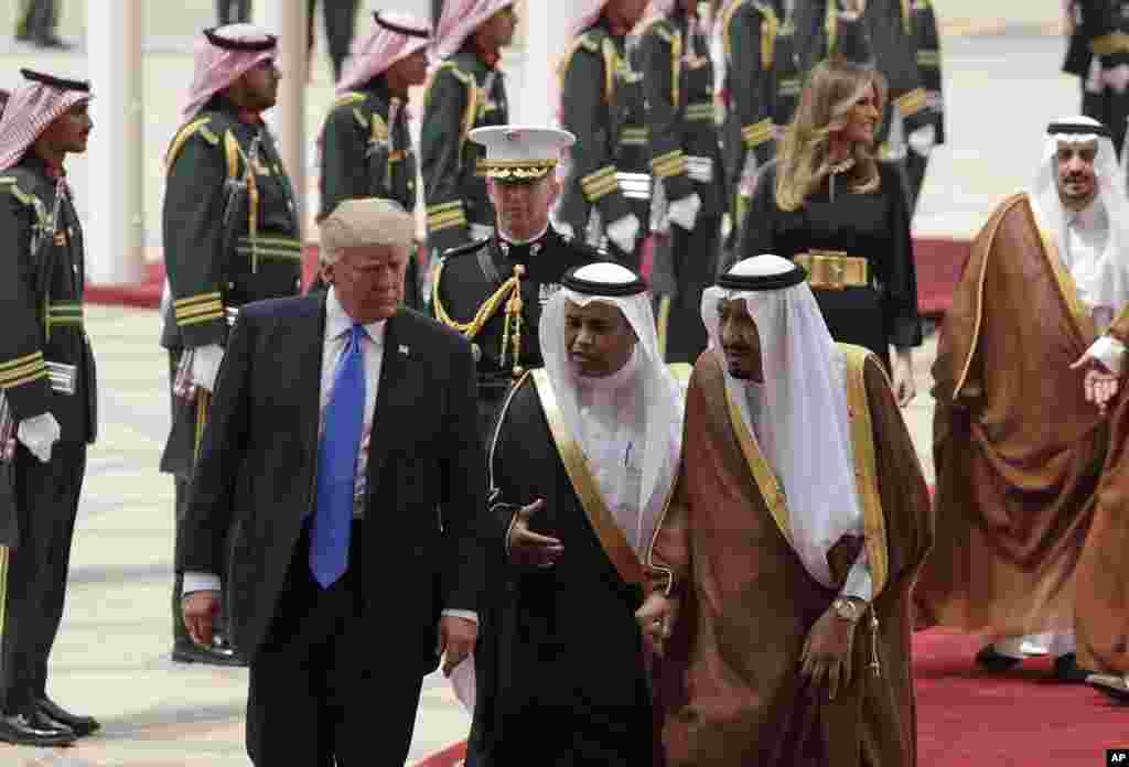 Le président Donald Trump et la première dame américaine, Melania Trump, à l’arrière, sont accueillis au pied de l’avion, à l’aéroport international roi Khalid, Ryad 20 mai 2017.