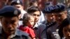 Reuters journalist Kyaw Soe Oo carrying his daughter is escorted by Myanmar police as he re-enter to the trial after a break Feb. 1, 2018, outside of Yangon, Myanmar.