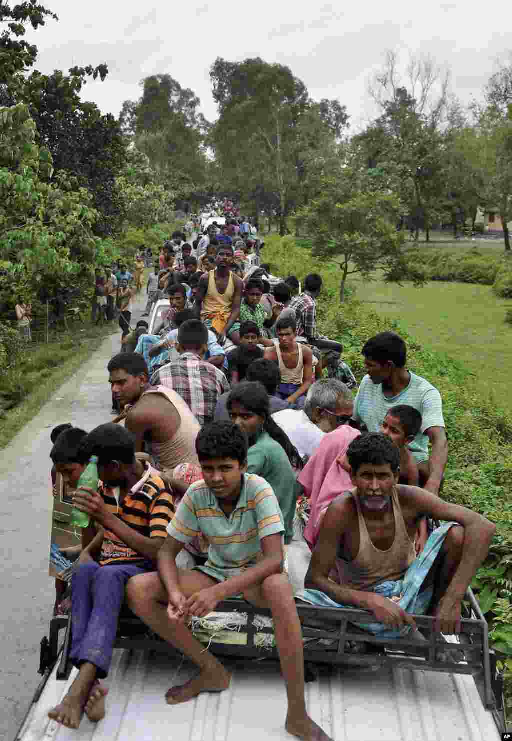 Indian villagers crowd on top of vehicles as people flee ethnic clashes in Kokrajhar, India, July 24, 2012.