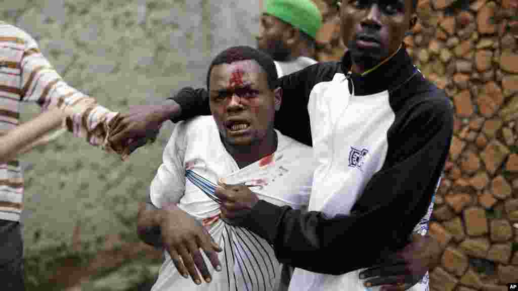 Jean Claude Niyonzima, un membre présumé d'Imbonerakure la milice de la jeunesse du parti au pouvoir, pris par une foule qui se rassemble autour de sa maison, alors que les manifestations se poursuivent contre la décision du président Pierre Nkurunziza de briguer un troisième mandat dans le quartier de Cibitoke de Bujumbura, au Burundi, jeudi 7 mai 2015.