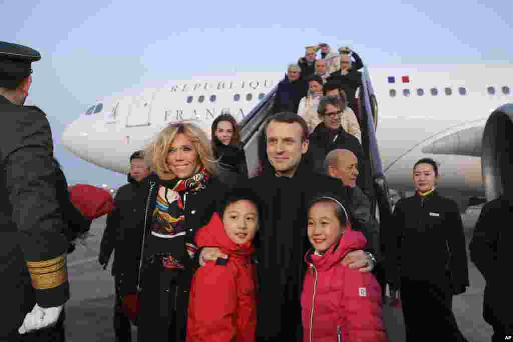 学生欢迎外宾。2018年1月8日，法国总统马克龙（Emmanuel Macron）和夫人布丽吉特&middot;马克龙（Brigitte Macron）在北京首都机场的停机坪和参加欢迎仪式的中国儿童合影。