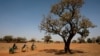 Girls carry water on their bicycles at a dispensary in Nedogo village near Ouagadougou, Burkina Faso, Feb. 16, 2018.