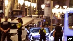 Des policiers déployés près d’une camionnette utilisée lors d’une attaque contre des passants sur l'allée centrale des Ramblas, au cœur touristique de la capitale catalane, 17 août 2017.