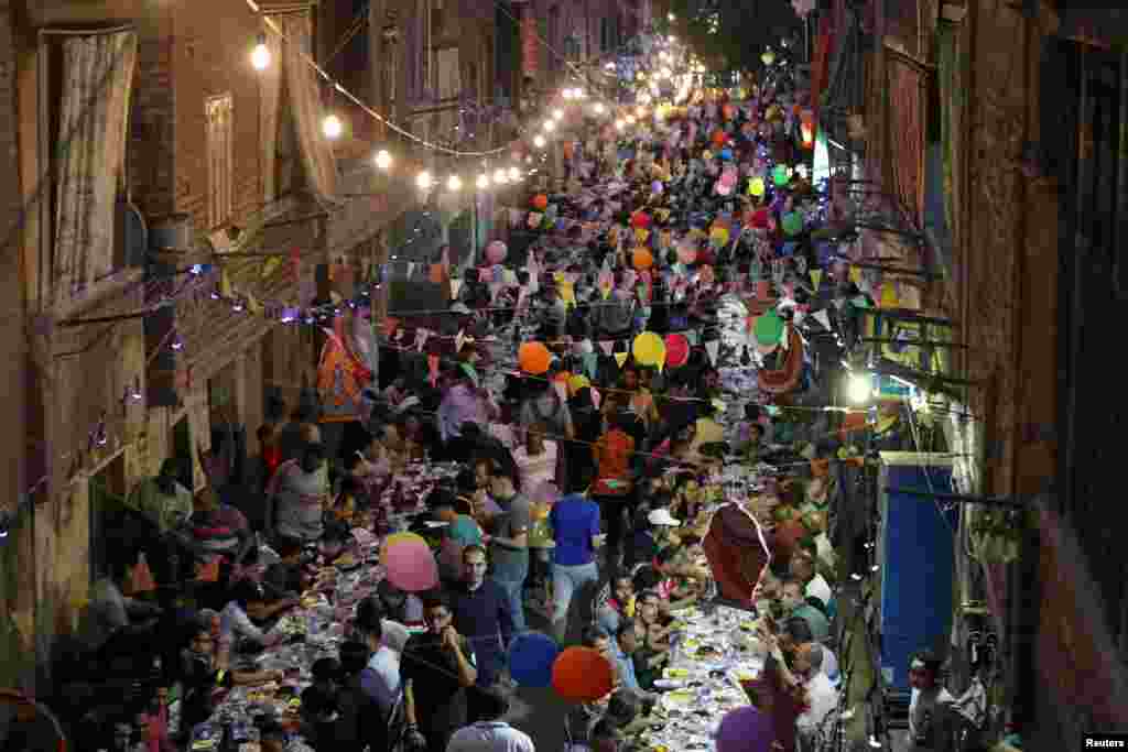 ប្រជាជន​នៃ​ តំបន់ Ezbet Hamada ស្រុក Cairo&#39;s Mataria ប្រទេស​អេហ្ស៊ីប​ប្រមូល​ផ្តុំ​គ្នា​បរិភោគ Iftar ដែល​អាហារ​បញ្ចប់​ការតម​របស់​ពួកគេ​នៅពេល​ព្រះអាទិត្យ​លិច​អំឡុង​ខែរ៉ាម៉ាដង់​កាលពី​ថ្ងៃទី២០​ ខែឧសភា ឆ្នាំ២០១៩។ &nbsp; &nbsp;