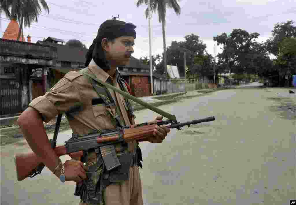 An Indian armed security man stands guard in a riot-hit locality in Kokrajhar, India, July 24, 2012.