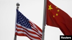人口學家易富賢認為，中國經濟永遠超不過美國。圖為美中國旗在一家美國公司駐北京的辦公樓外飄揚。 （路透社2021年1月21日資料照）