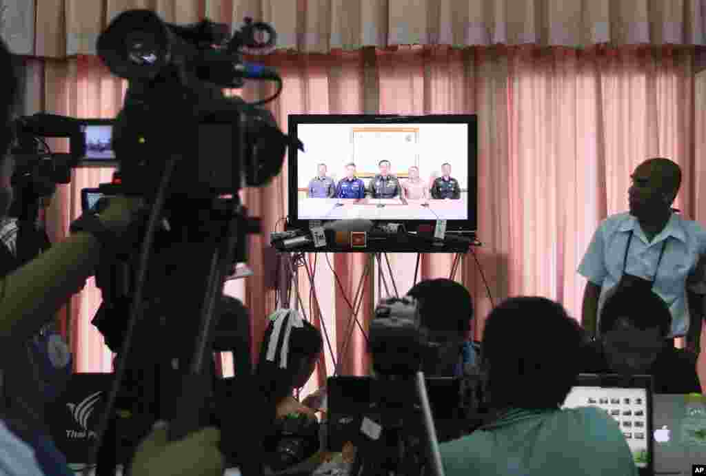 Thai journalists and other foreign press watch the TV broadcast announcement of the coup by the Thai Armed Forces chiefs, at the press center of the Army Club, in Bangkok, May 22, 2014.