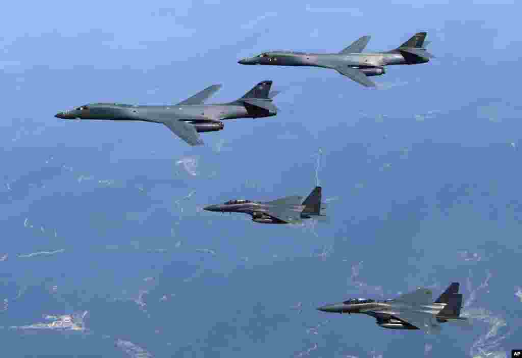 韩国国防部发布的照片显示,美国空军B-1B轰炸机(上面两架)和韩国F-15K战斗机在韩国上空飞行(2017年6月20日)。
