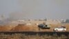 FILE - Free Syrian Army fighters along with Kurdish People's Protection Units (YPG) fighters gather at the eastern entrance to the town of Tel Abyad of Raqqa governorate.