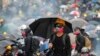 FILE - Protesters face police on a street during a pro-democracy protest, Hong Kong, Aug. 31, 2019. 