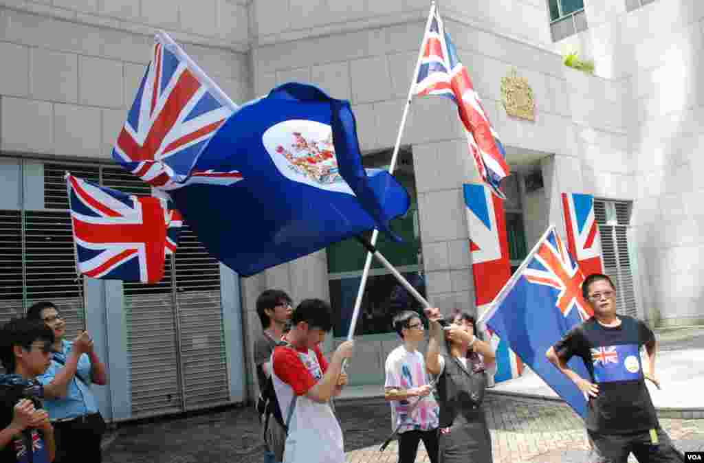 香港人優先約十名成員在英國駐港總領事館大門前,揮舞英國國旗及港英時代的香港旗 (美國之音湯惠芸)
